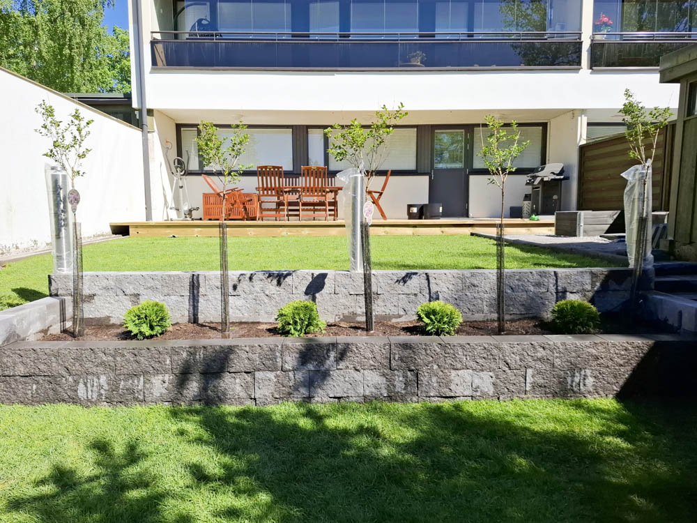 Taloyhtiö on 60-luvulla rakennettua pelkistettyä arkkitehtuuria ja piha mukautettiin siihen